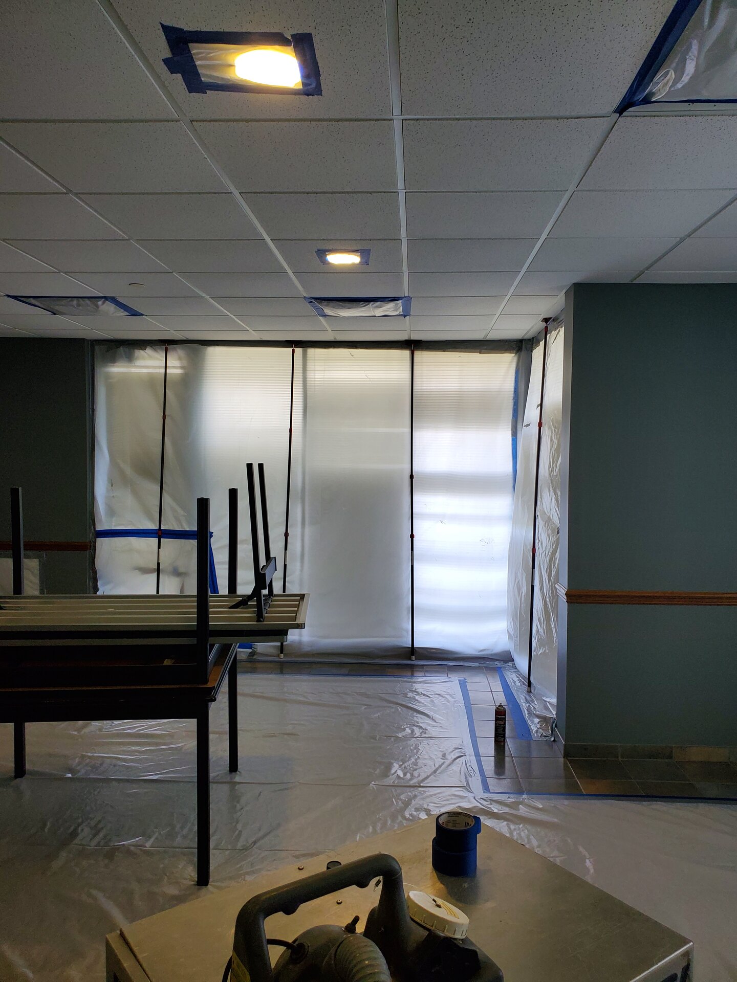 Commercial corridor with plastic wall and door barriers and the floor protected during containment
