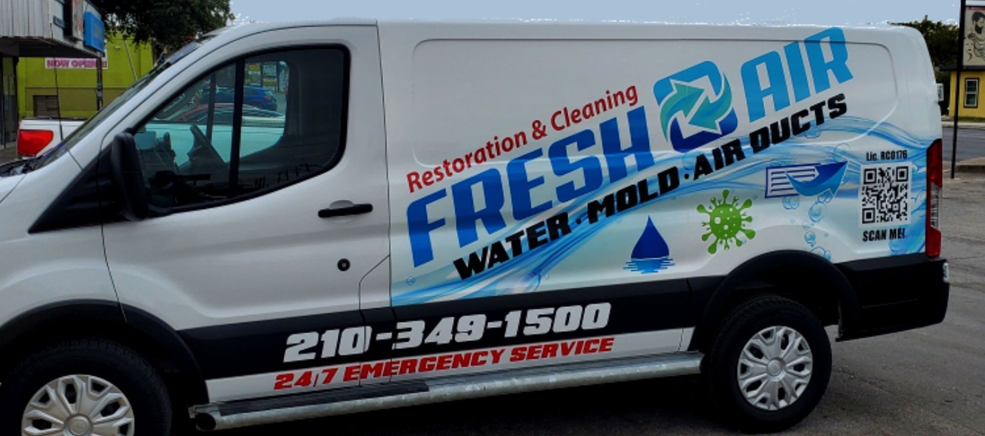 Side of a Fresh Air Restoration & Cleaning service van with the company logo and phone number